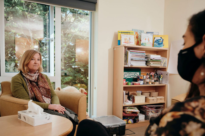 Image of bereavement counsellor talking to patient, box of tissues on table