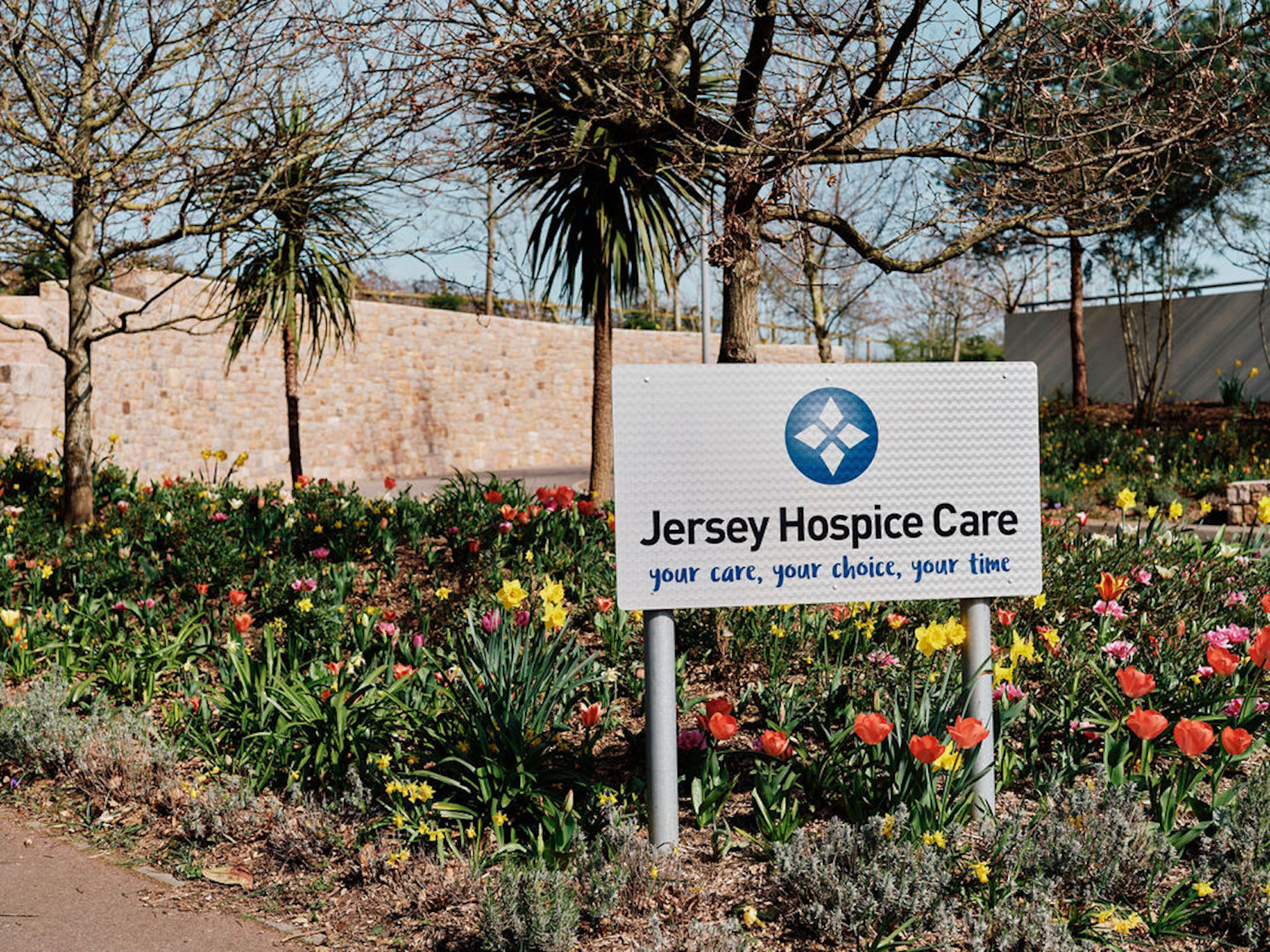 Image of Jersey Hospice Care sign surrounded by flowers