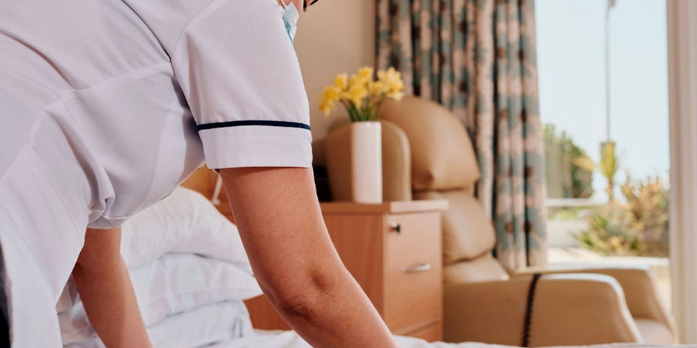Image of nurse making a bed in room at Jersey Hospice Care In Patient Unit