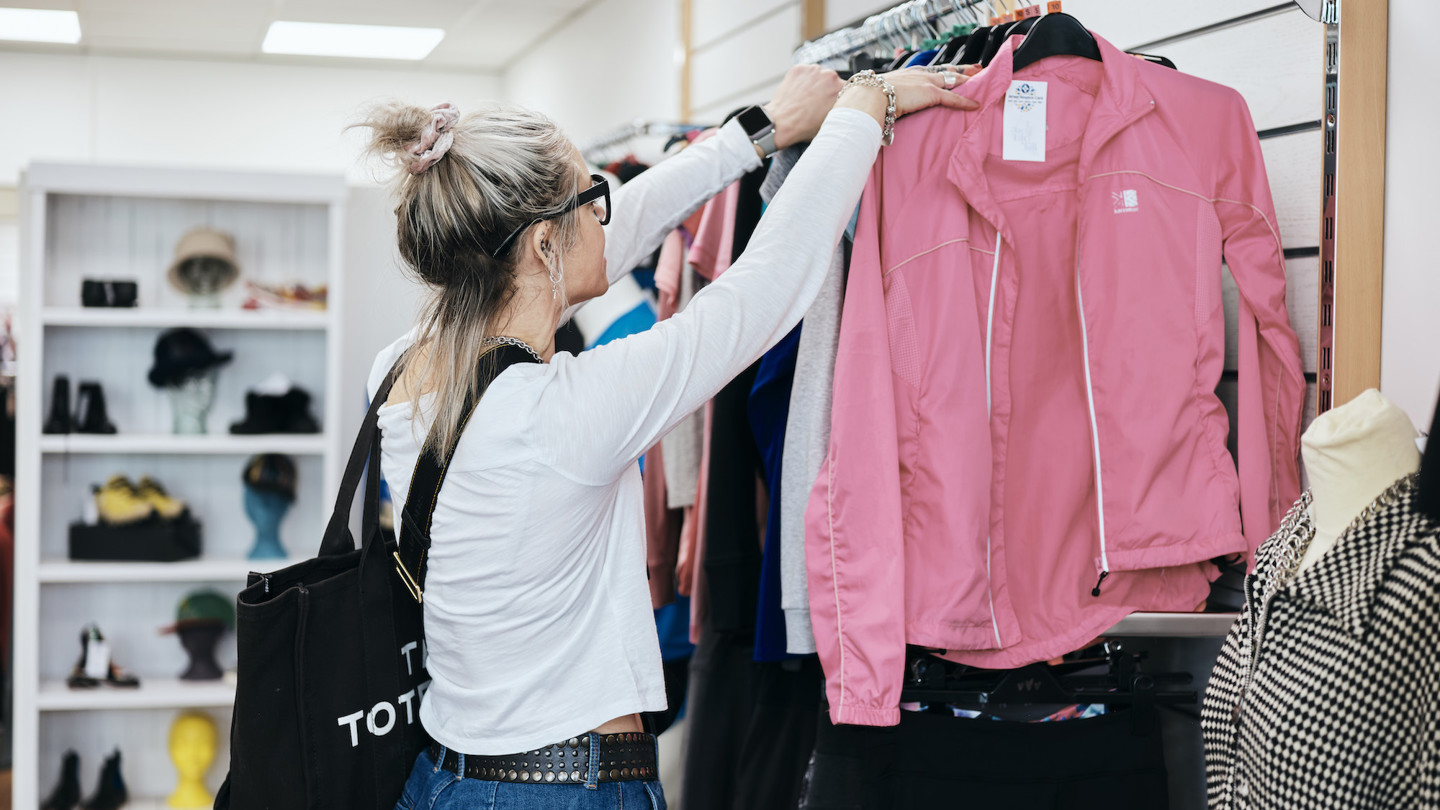 Image of  customer browsing clothes in st helier fundraising store 