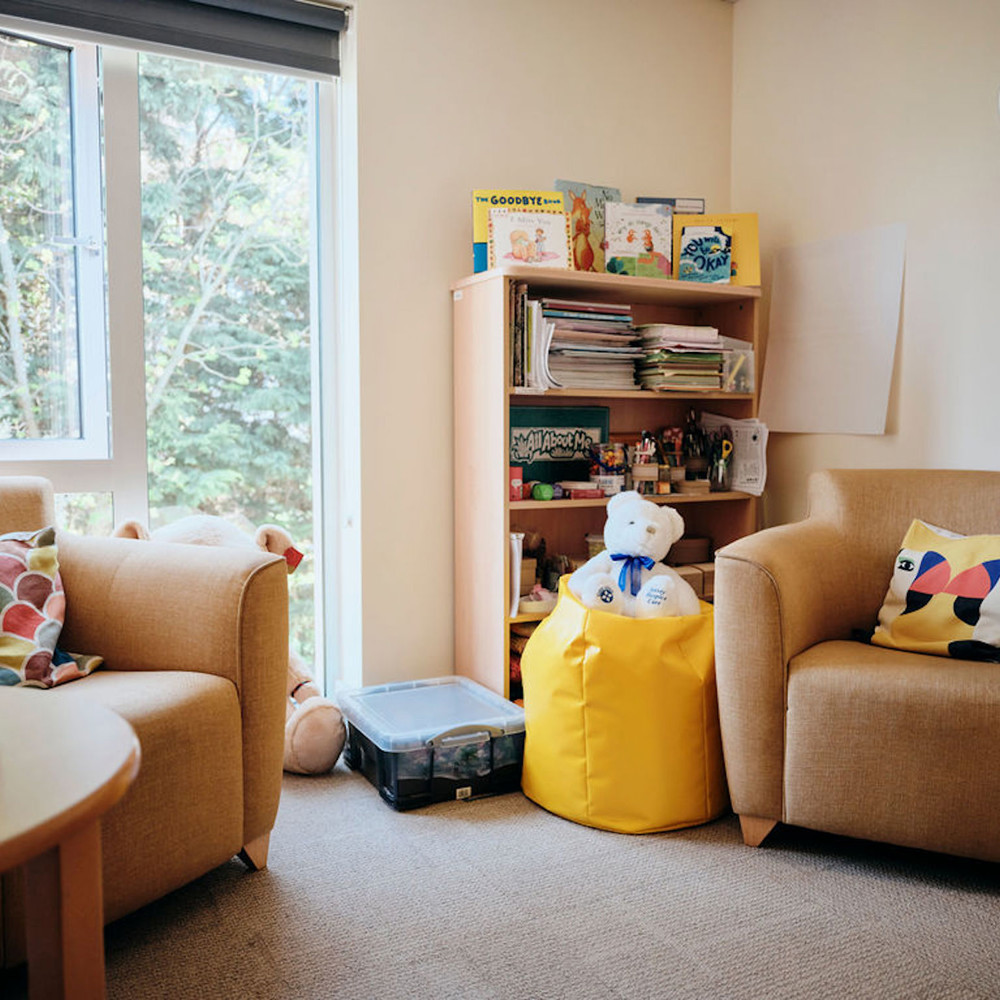 Image of bereavement room - two chairs, table and bookshelf in corner