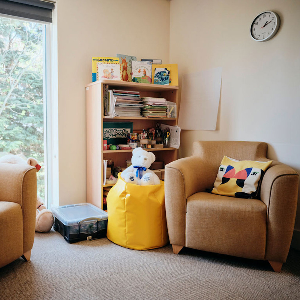 Image of bereavement room - two chairs, table and bookshelf in corner