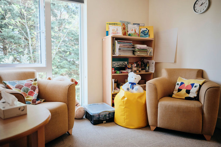 Image of bereavement room - two chairs, table and bookshelf in corner