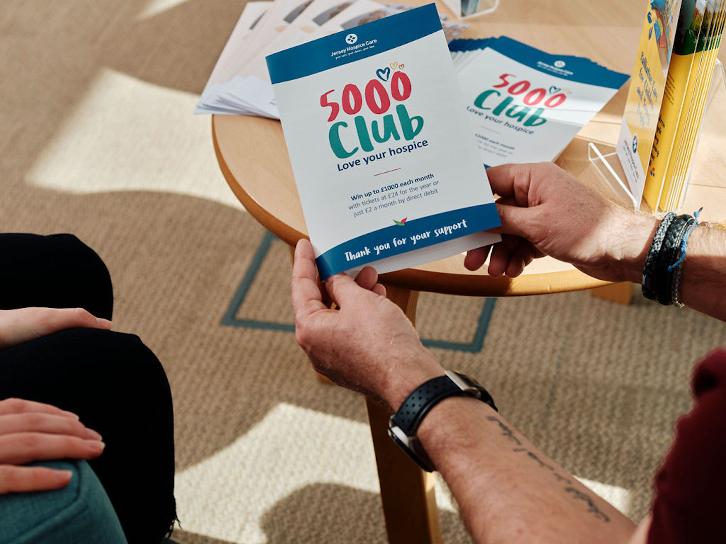 Image of man holding 5000 club lealet