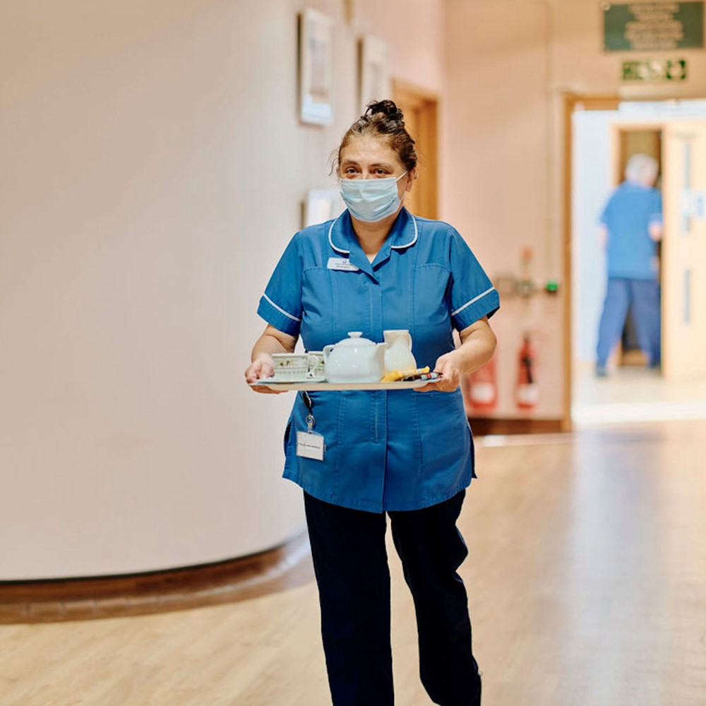 Image of health care assistant carrying tea tray 