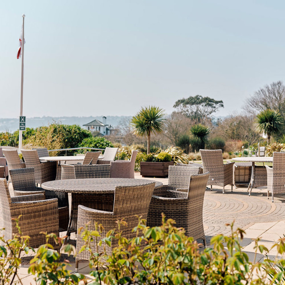 Image of tables and chairs in Hospice gardens with flag flying