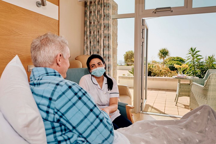 Image of nurse next to patients bed
