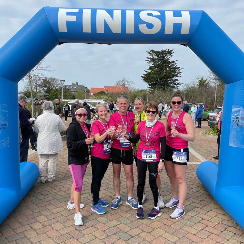 Group of women at Hospice Half Marathon finishing arch