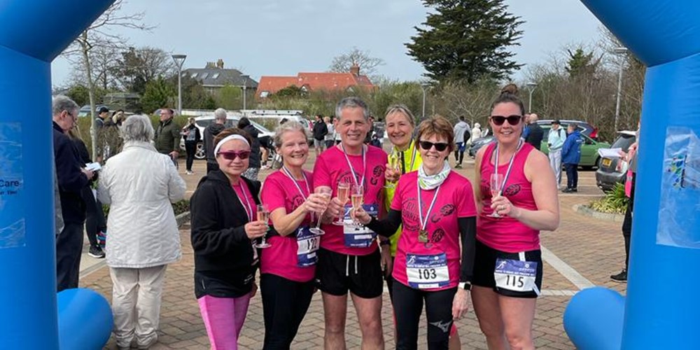 Group of women at Hospice Half Marathon finishing arch