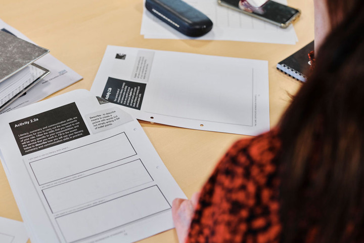 Image of woman taking notes in education course