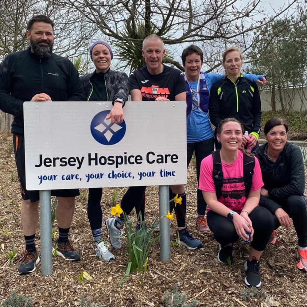 Group of runners by Hospice sign 
