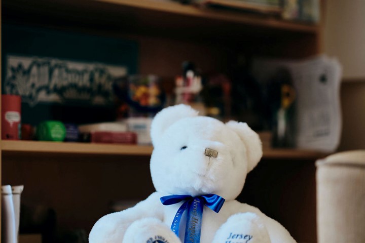 Image of white teddy bear with Jersey Hospice Care written on it's foot. 