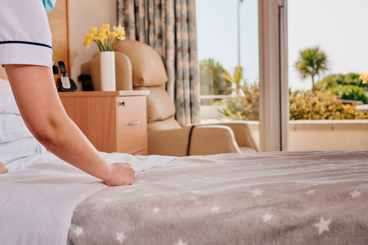 Image of Nurse making a bed in patient room