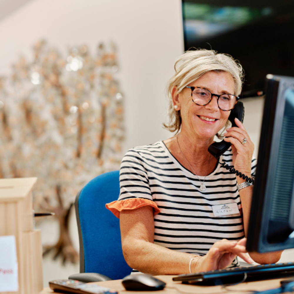 Image of volunteer on reception at jersey hospice care