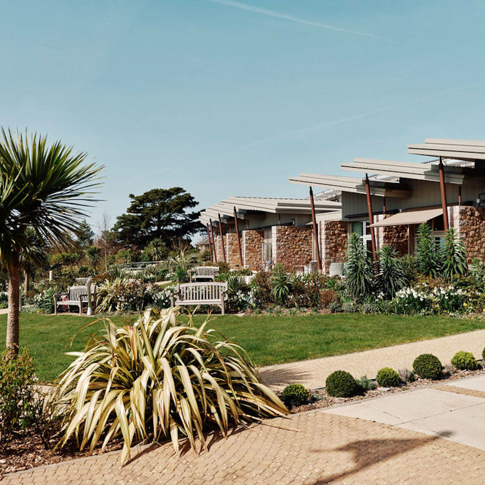 Image of hospice gardens with in patient unit in the background 