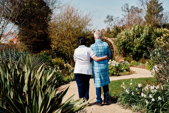 Image of nurse and patient walking in gardens at Jersey Hospice Care