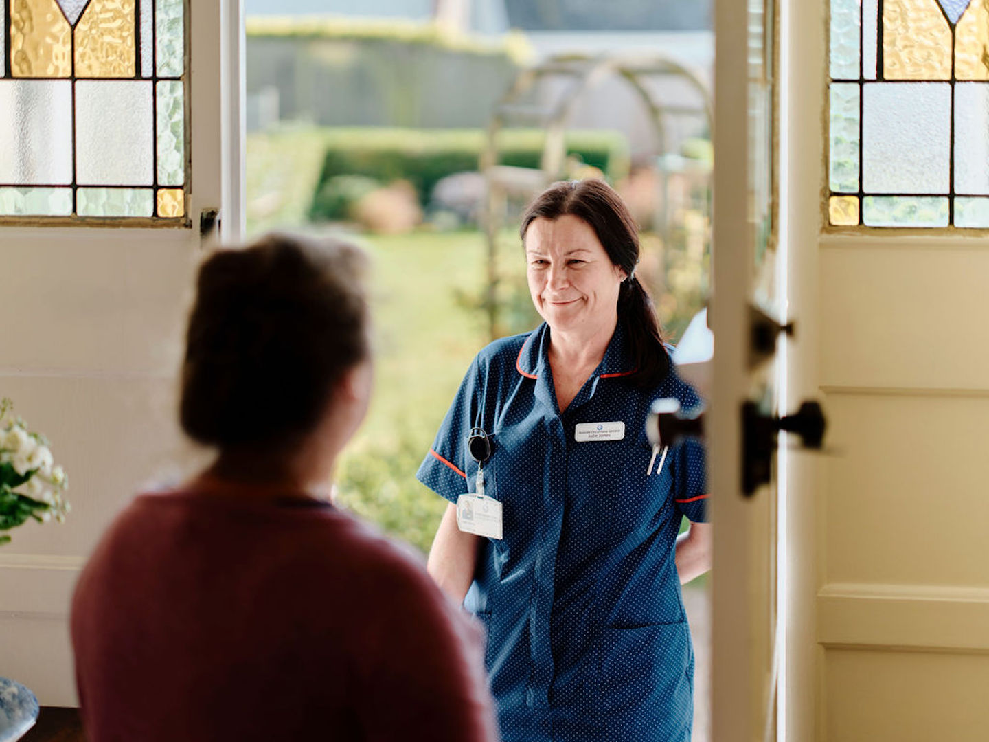 Image of community nurse at doorway visiting patient 