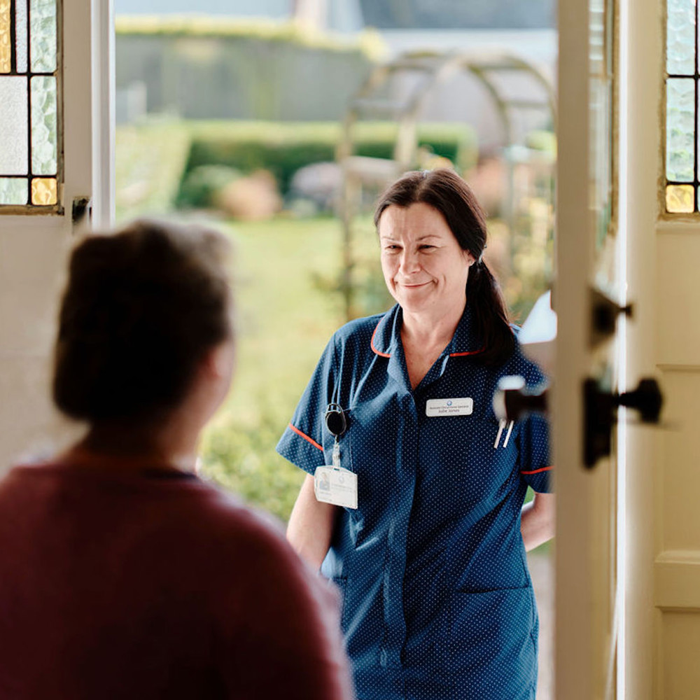 Image of community nurse at doorway visiting patient 