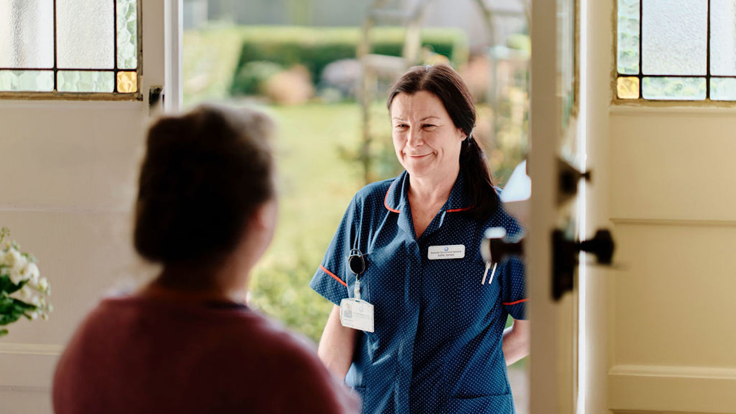 Image of community nurse at doorway visiting patient 