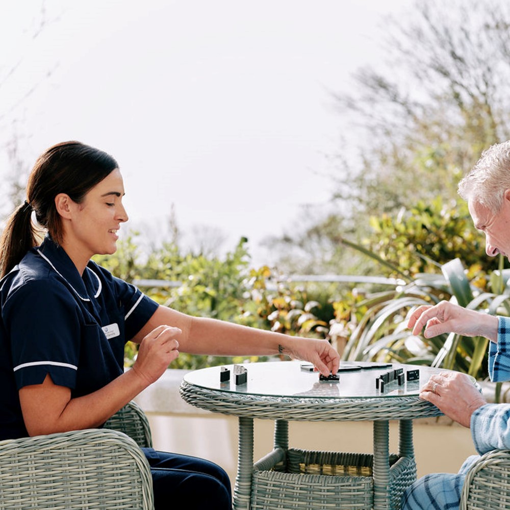 Nurse and patient playing dominoes