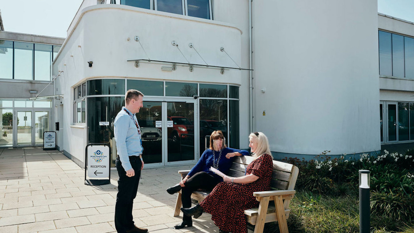 Image of Hospice building with staff outside talking