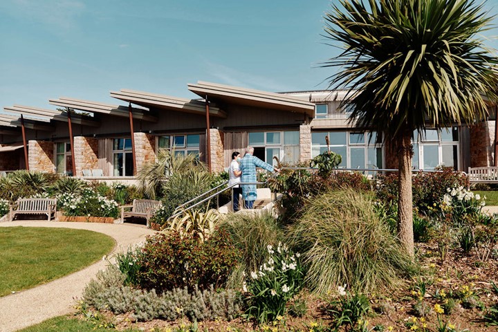 Image of nurse and patients on steps in gardens at Jersey Hospice Care